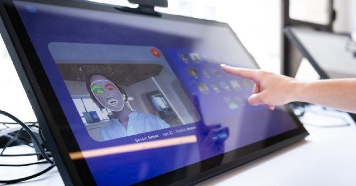 Un formatore aiuta una persona anziana a utilizzare un computer portatile